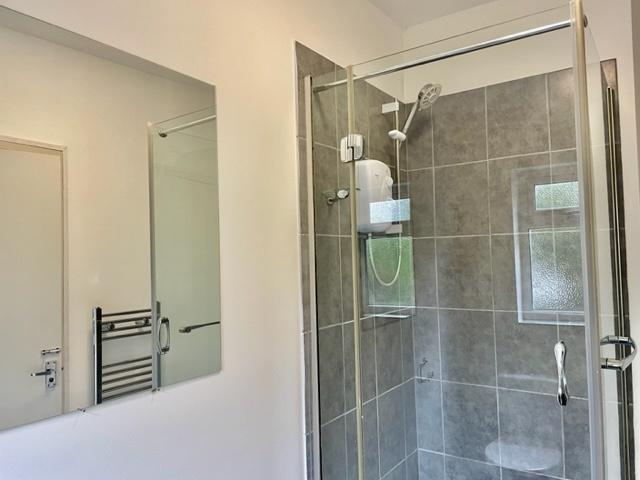Bright modern bathroom featuring a fully tiled ...