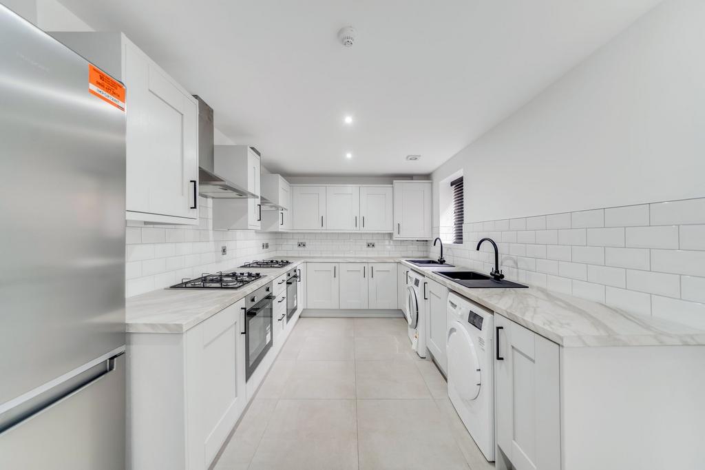 Modern, bright kitchen featuring sleek white ca...