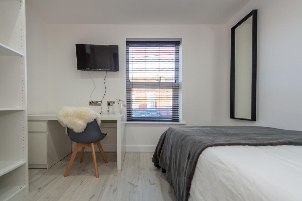 A spacious and modern master bedroom featuring ...