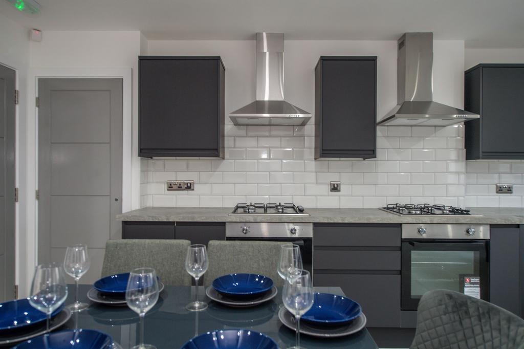 Modern kitchen with sleek dark cabinets, stainl...