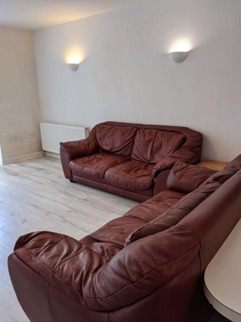 A cozy living room featuring two brown leather ...