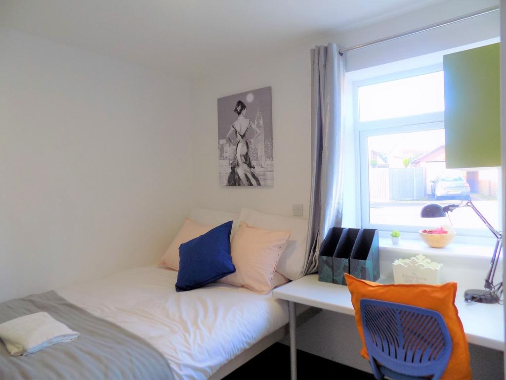 Bright, tidy single bedroom with a made bed, st...