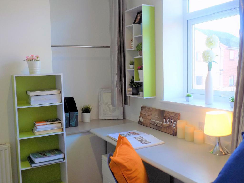 Bright, tidy study area with a long desk under ...