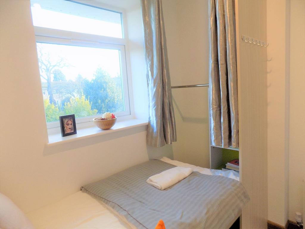 Bright single bedroom with a large window provi...