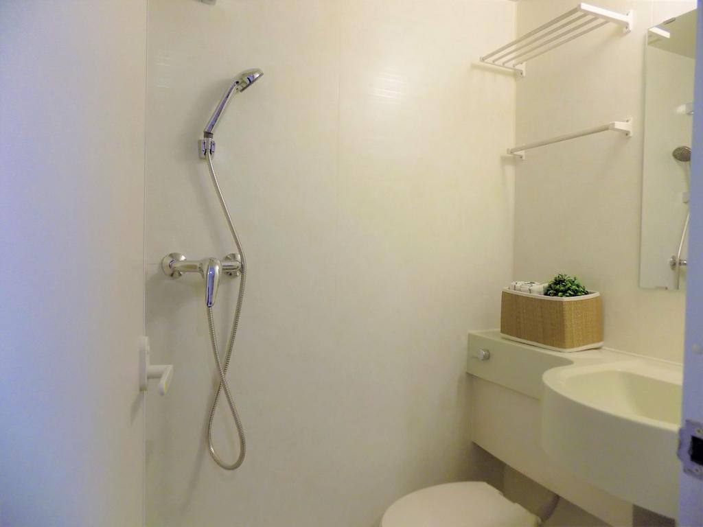 Compact, well-kept bathroom with a handheld sho...
