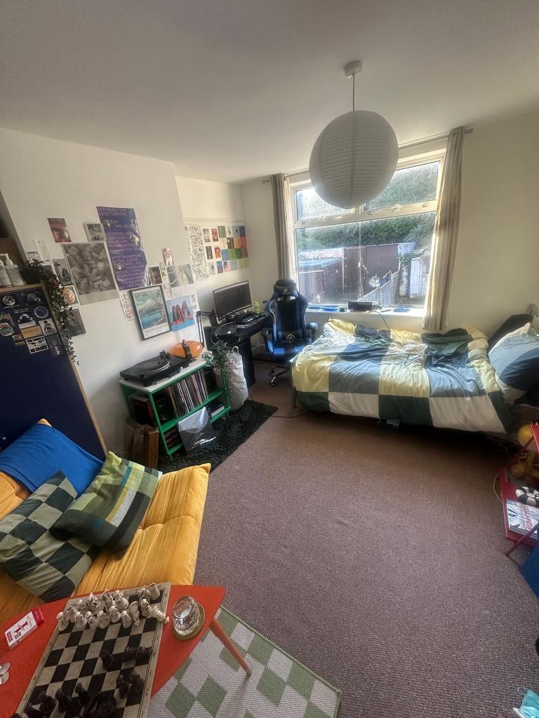 Bright, well-furnished bedroom with a large win...