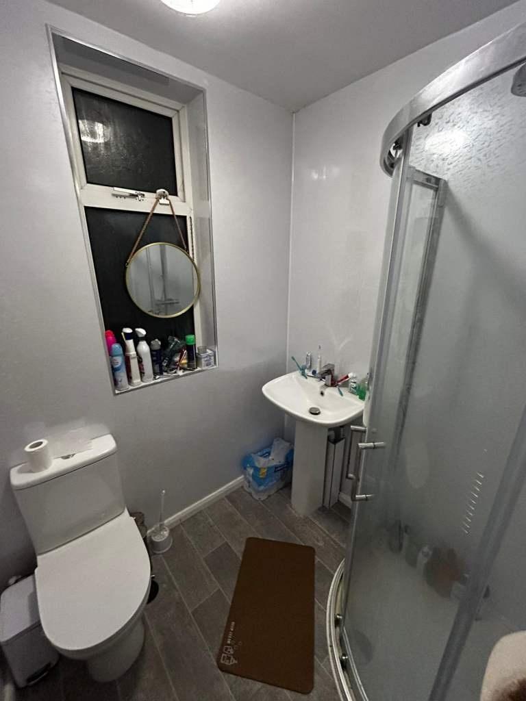 Compact, modern bathroom with a corner shower, ...