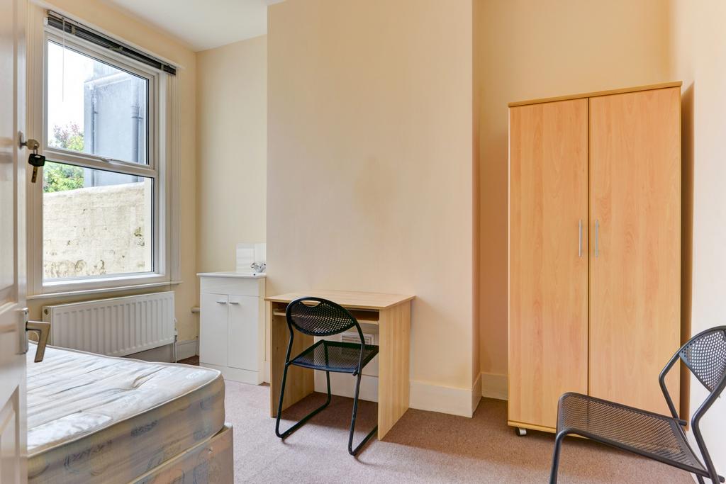 A compact, tidy room with a small toilet area. ...