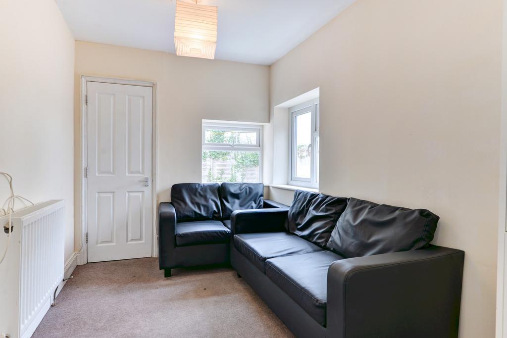 Bright, simply furnished living room with an L-...