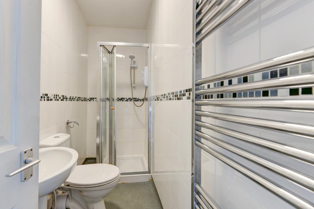 A clean, modern bathroom with a large shower en...