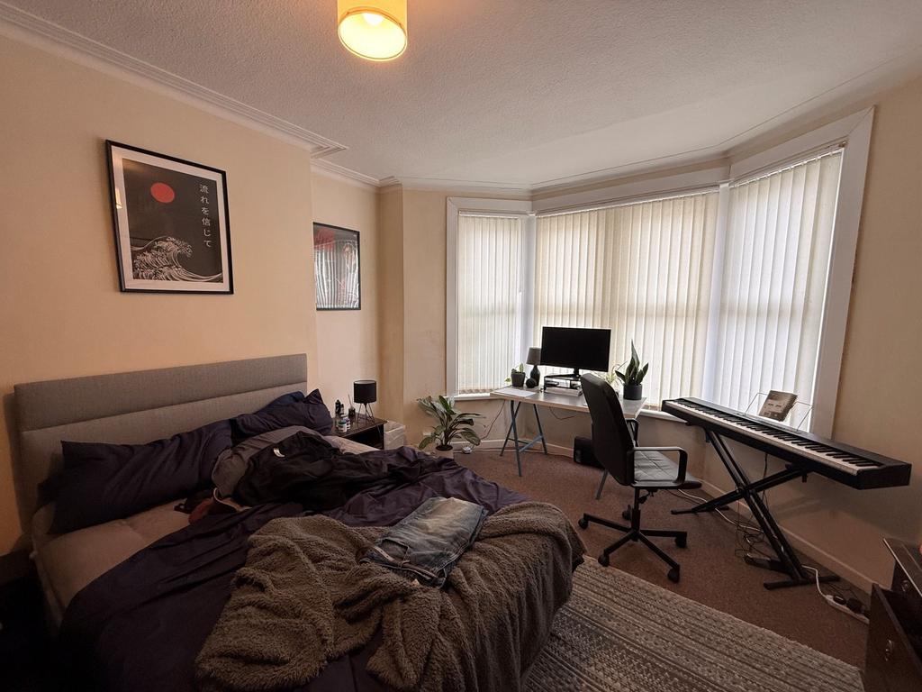 Spacious double bedroom with a large bay window...