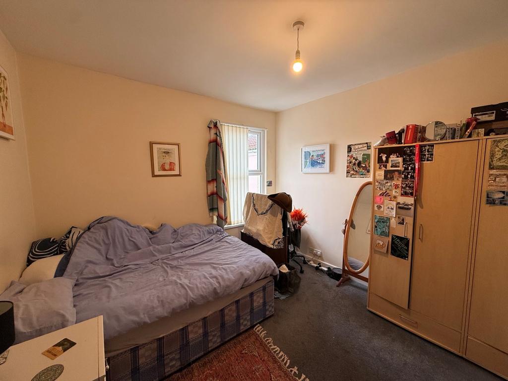 Bright, neatly furnished bedroom with a comfort...
