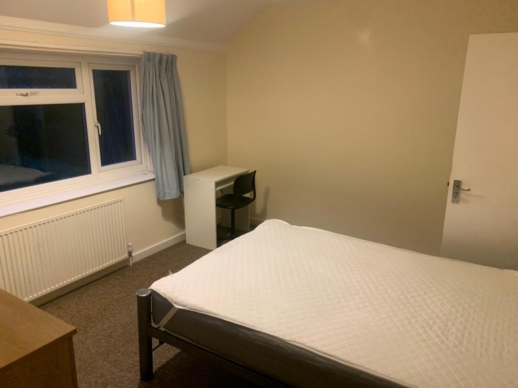 A spacious and well-lit double bedroom, perfect...