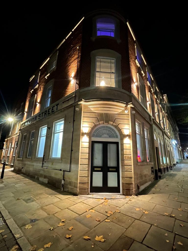 Well-lit corner building on Major Street with e...