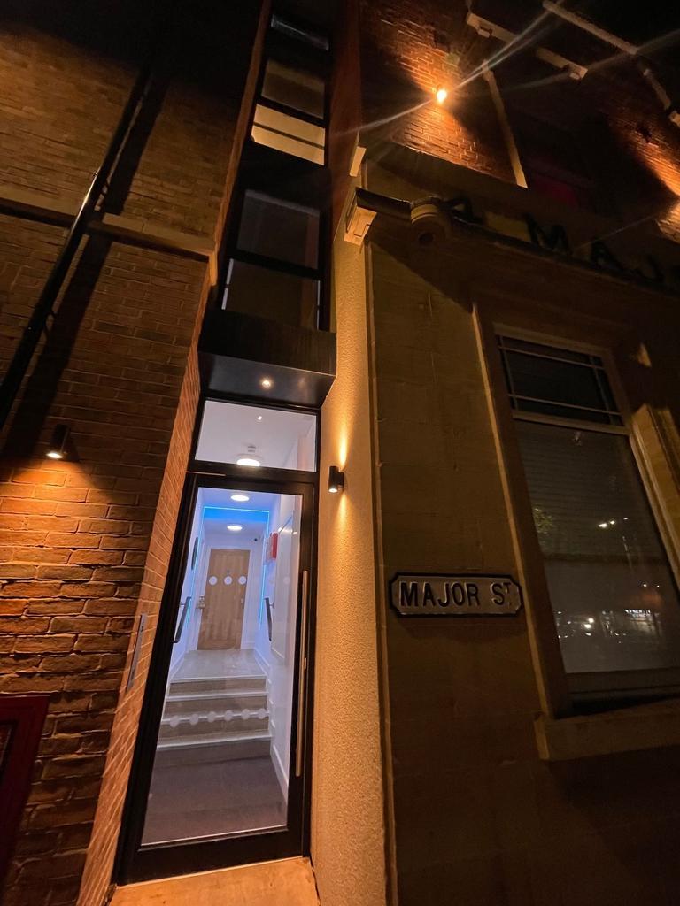 Well-lit street entrance on Major St with moder...