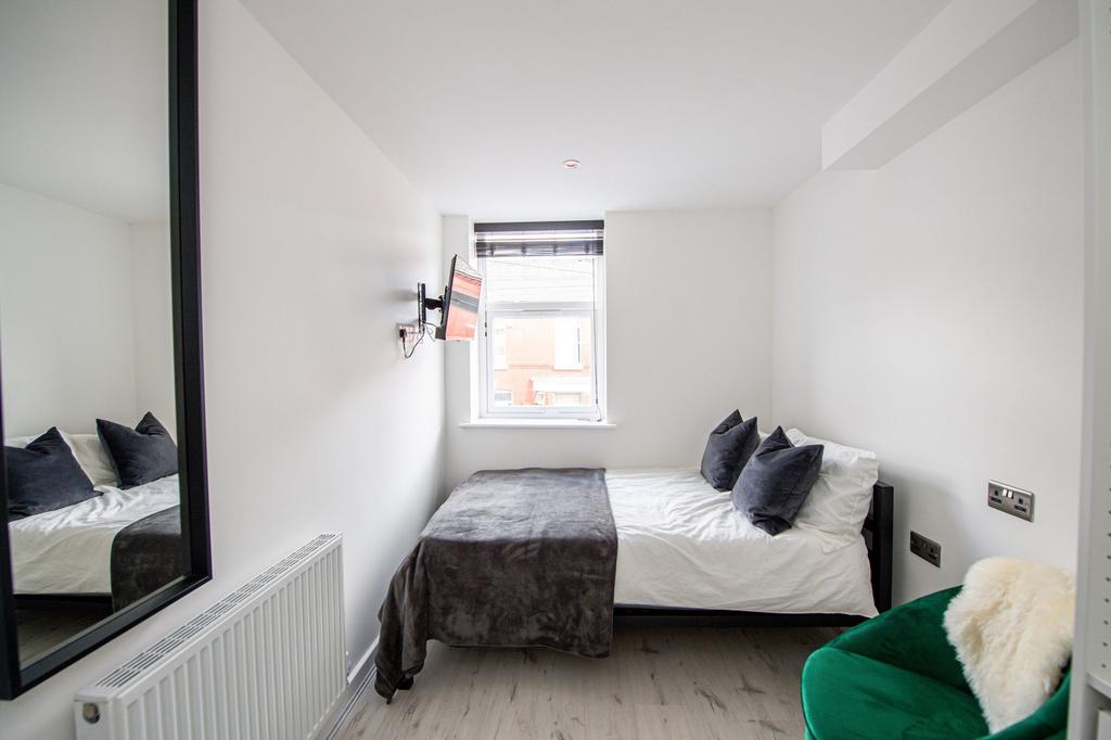 Bright and modern bedroom featuring a comfortab...