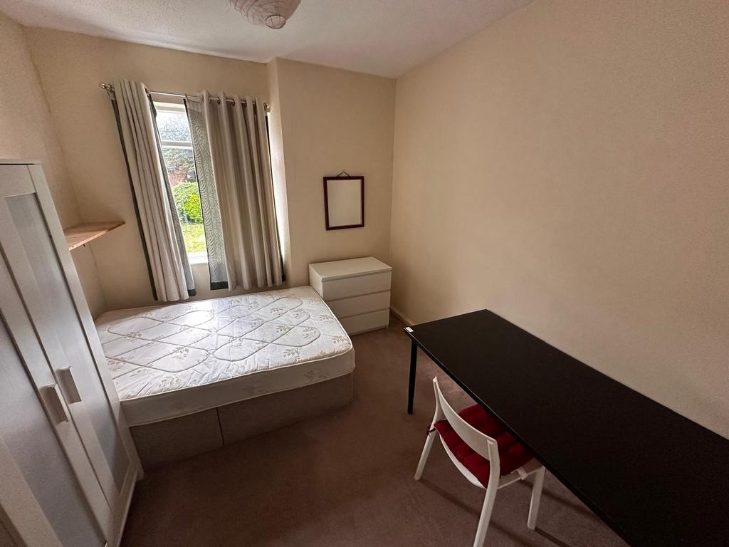 Bright, simply furnished single bedroom with a ...
