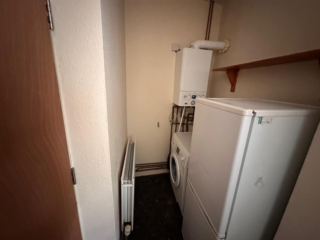 Compact utility/storage room with fitted radiat...