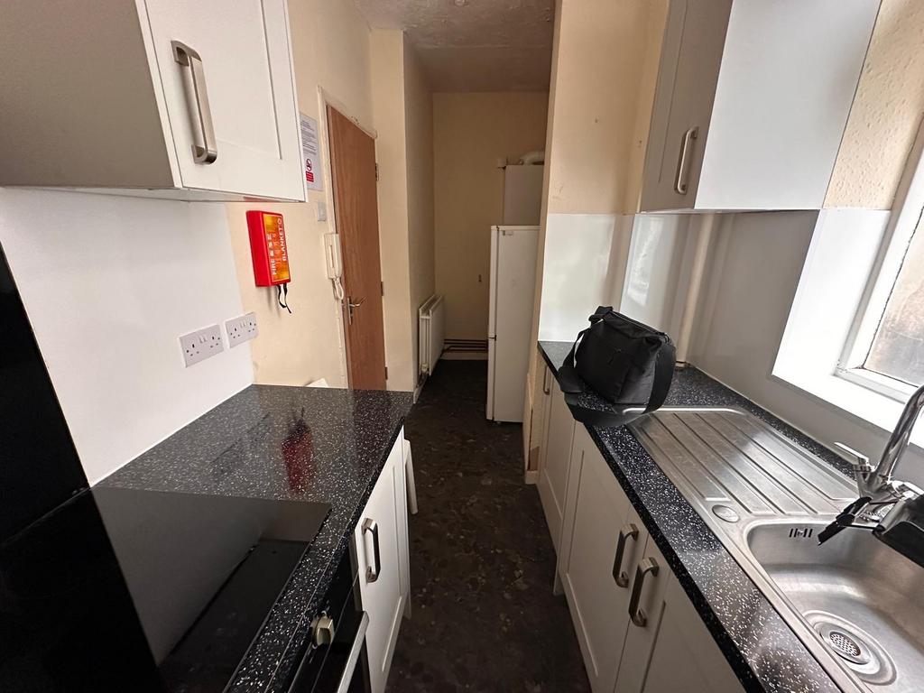Bright galley kitchen with modern speckled work...