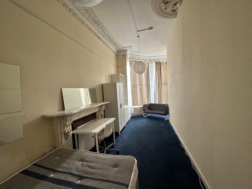 Long single bedroom with high ornate ceilings, ...