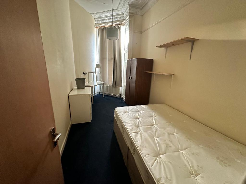 Narrow single bedroom with a mattress on a diva...