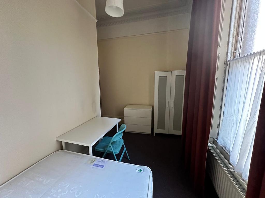Bright single bedroom with a large sash window,...