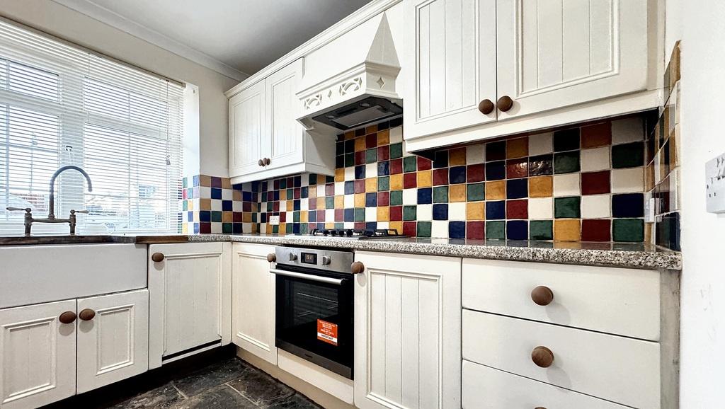 Bright, well-maintained kitchen with white shak...