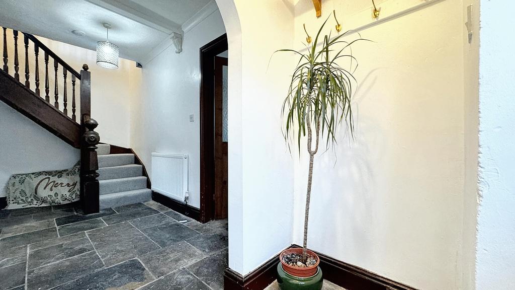 Bright, welcoming hallway with stone tile floor...