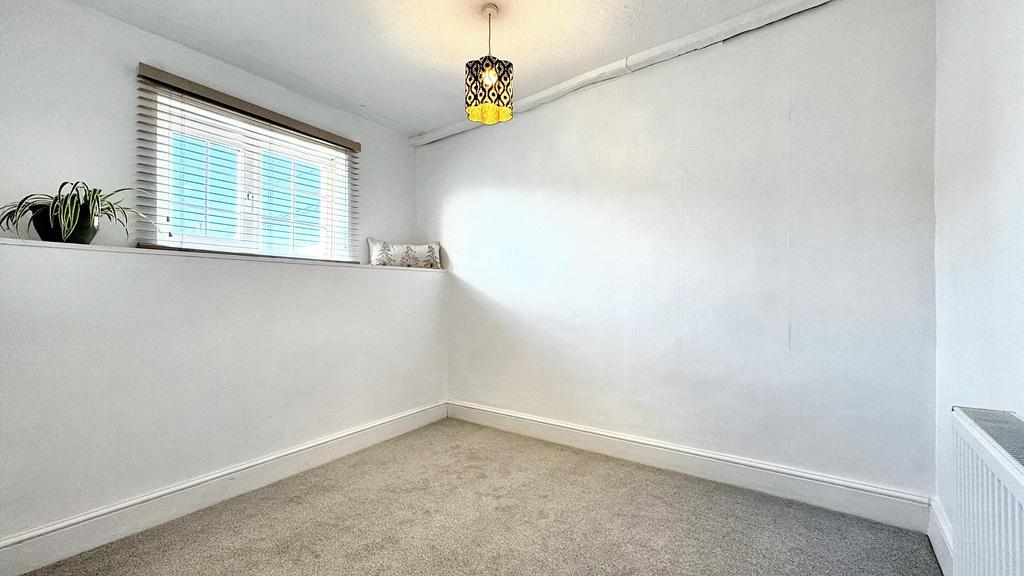 Bright, neutrally decorated small bedroom with ...