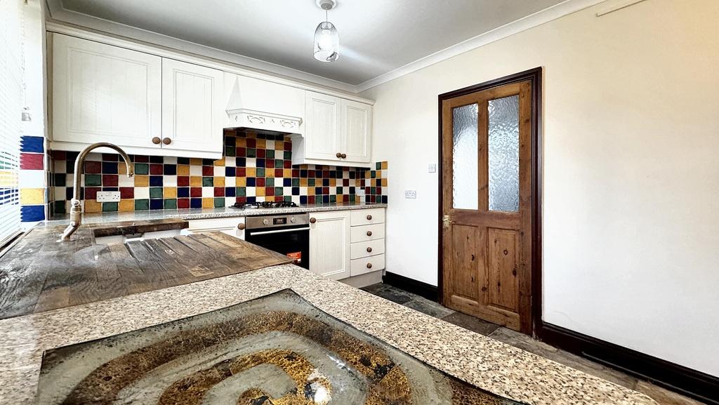 Bright, well-kept kitchen with patterned tile s...