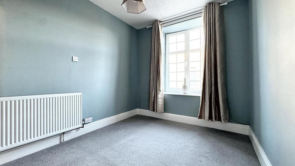 Bright, freshly painted bedroom with a large sa...