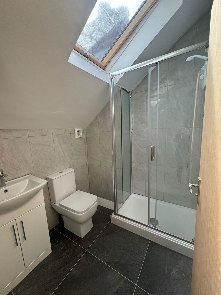 Bright modern bathroom with slate-style floor t...