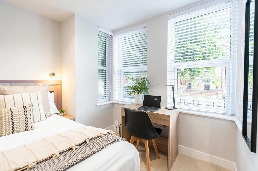 Bright and welcoming bedroom featuring a cozy b...