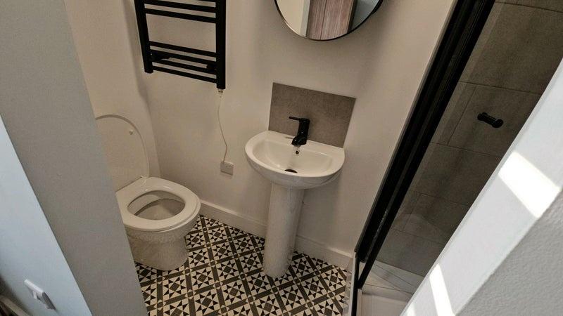 Modern small bathroom with patterned floor tile...