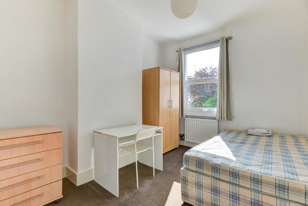 A bright and simple student bedroom featuring a...