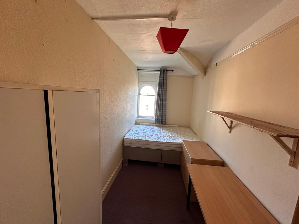 Long single bedroom with a raised single bed at...