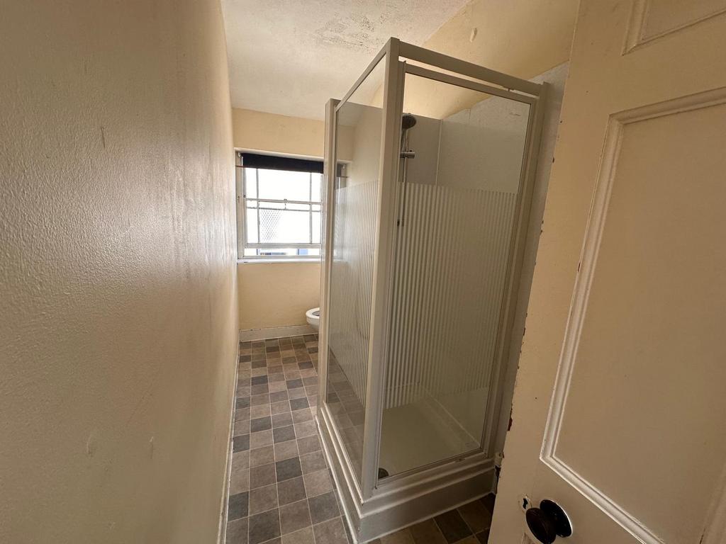 Narrow bathroom with a shower cubicle and natur...