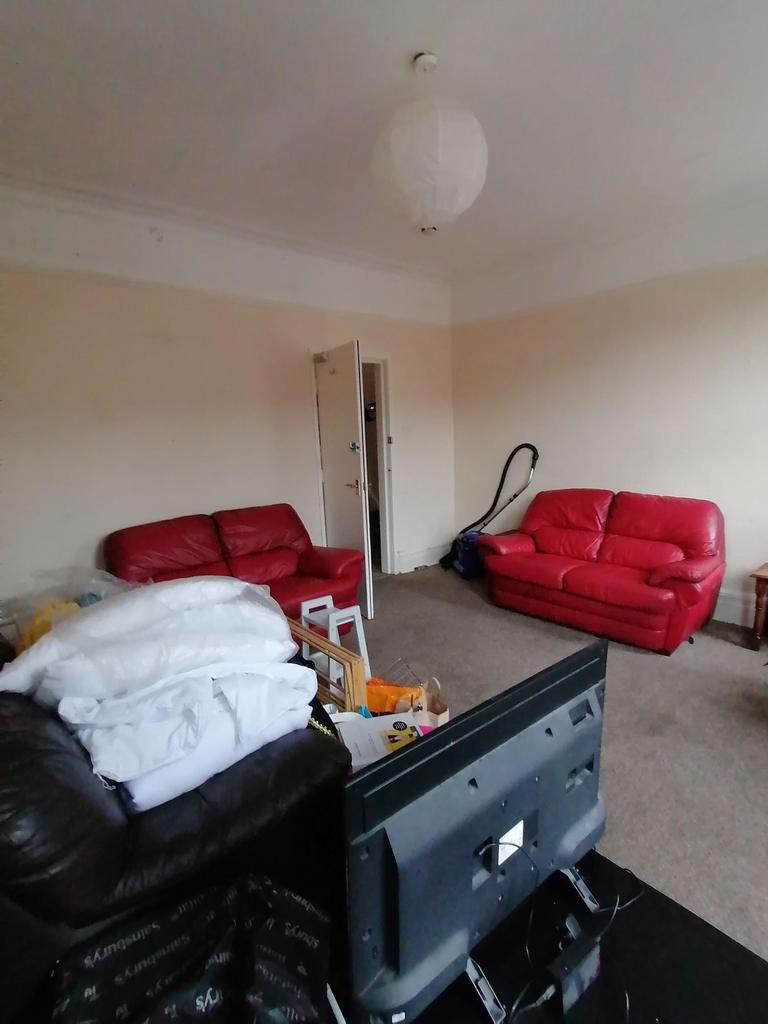 Spacious living room with high ceilings and two...