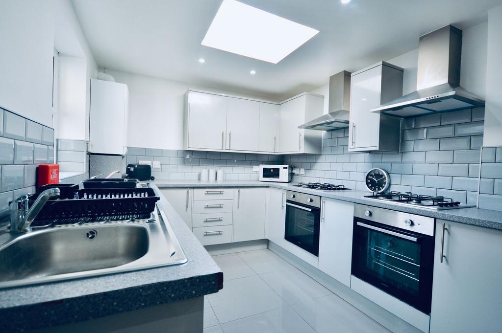 A modern, bright kitchen featuring white cabine...