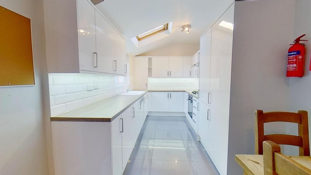 Bright, modern galley kitchen with high-gloss w...