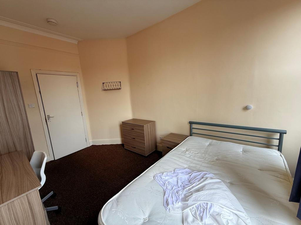 Bright, simply furnished bedroom with a double ...