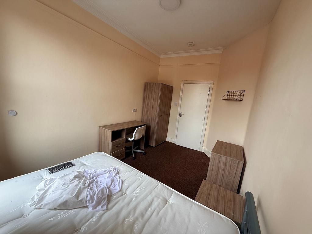 Bright, simply furnished single bedroom with a ...