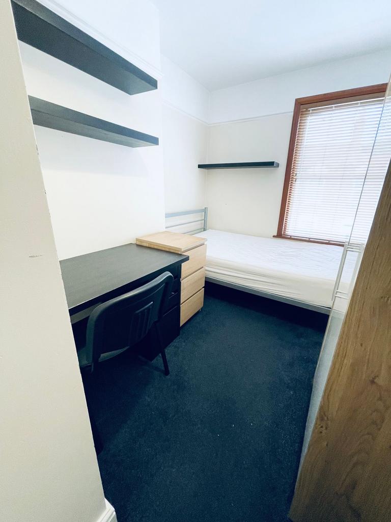 Bright, simply furnished single bedroom with a ...
