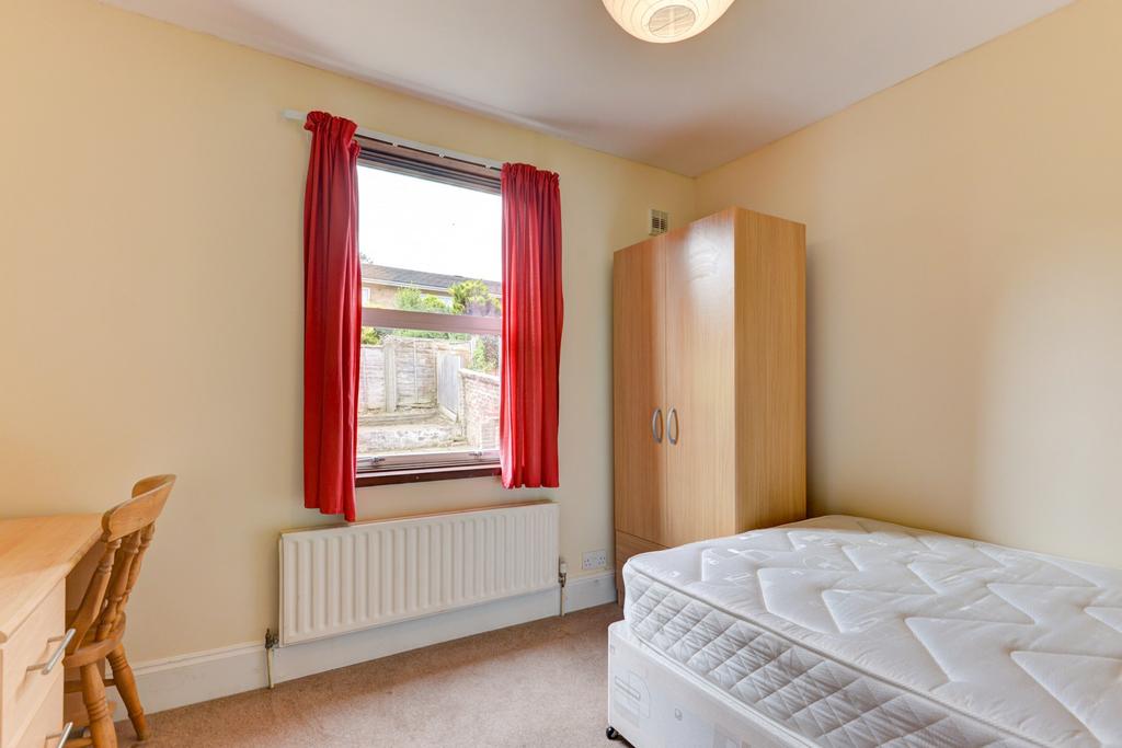 Bright, simple bedroom with a comfortable singl...