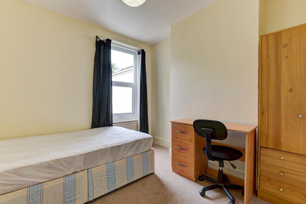 A tidy and bright single bedroom featuring a si...