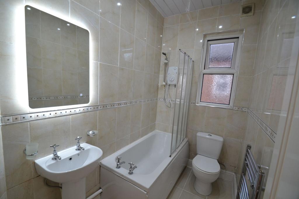 Bright and clean bathroom featuring a bathtub w...