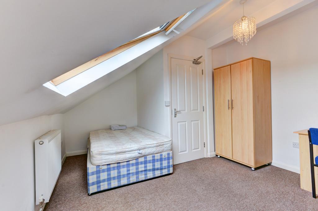 A cozy bedroom with a single bed and a wardrobe...