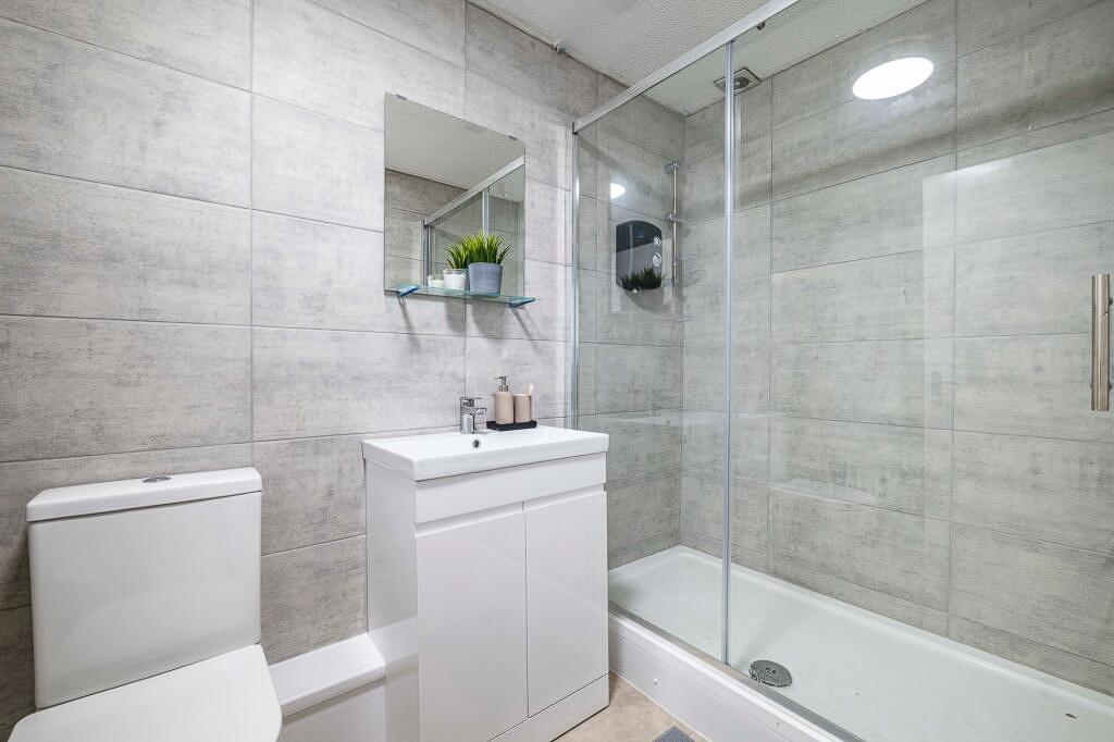 Modern tiled bathroom with a glass-front shower...