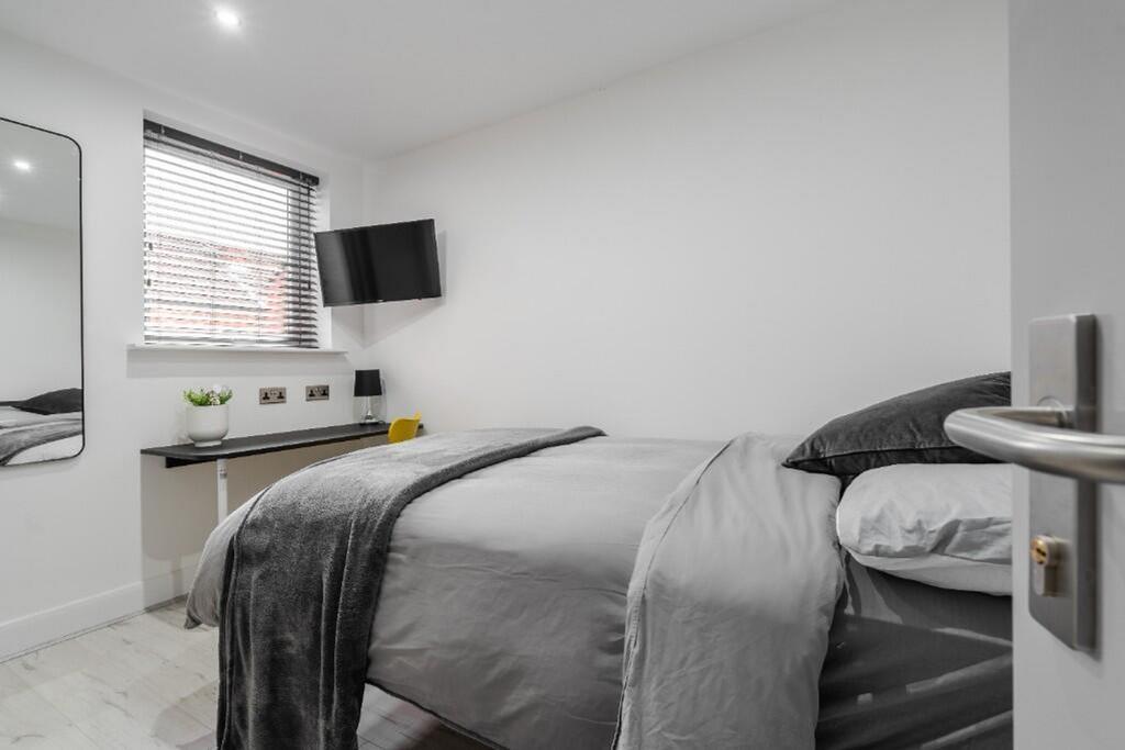This inviting double bedroom features a cozy be...