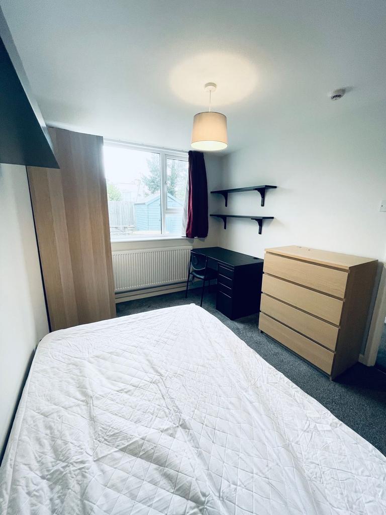 Bright, simply furnished bedroom with a double ...
